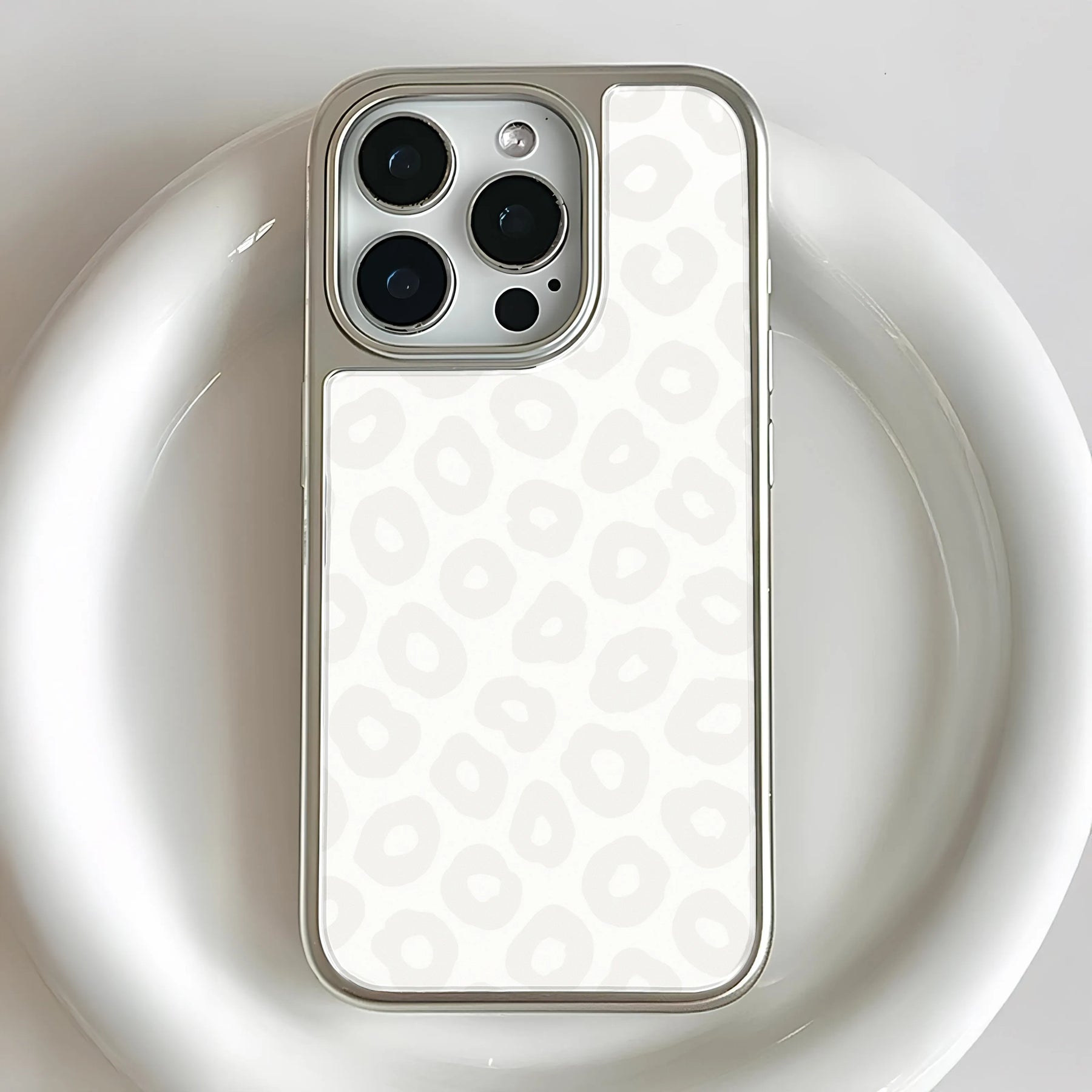 Silver and white leopard pattern smartphone case, close-up rear camera angle