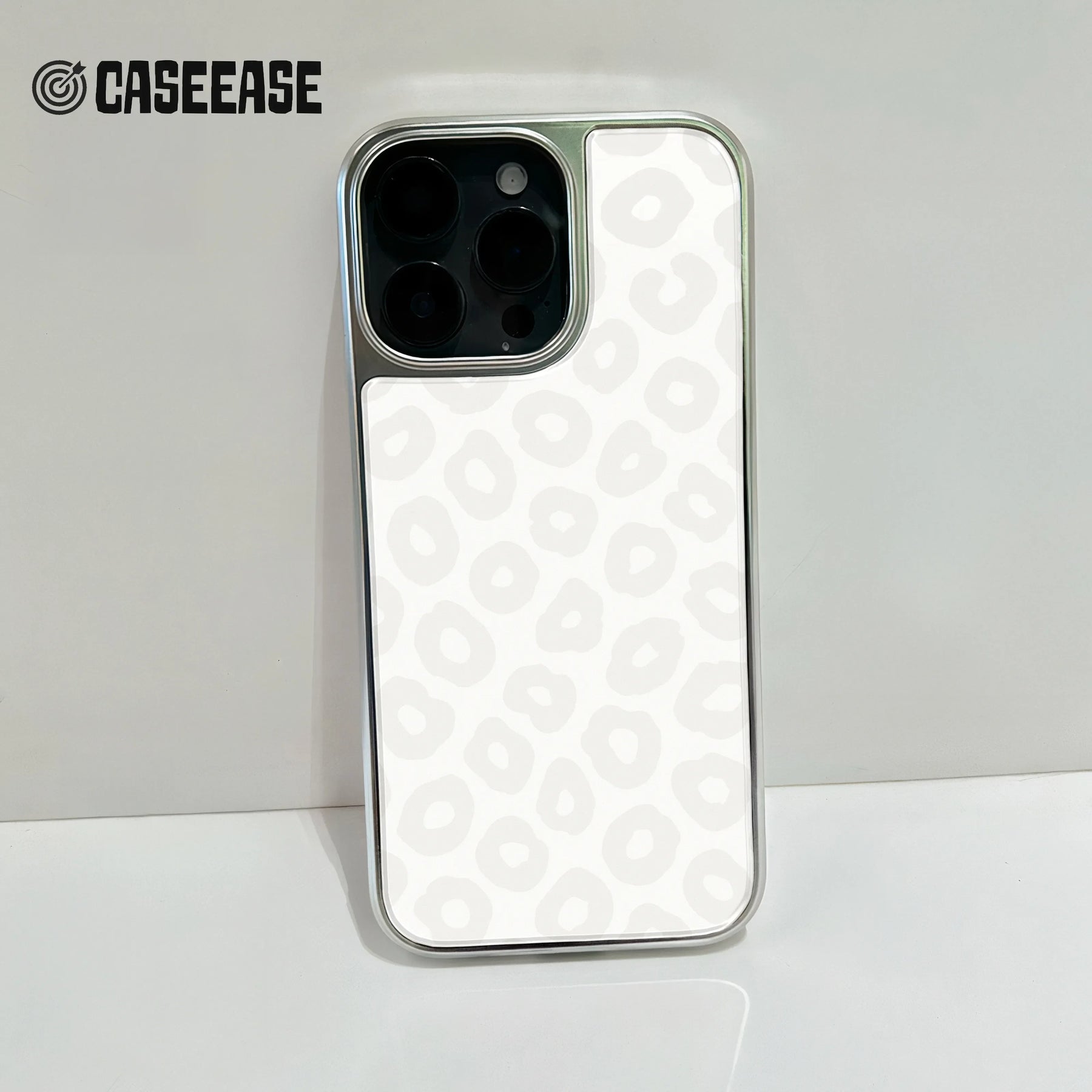 White leopard print smartphone case with silver edges, rear camera close-up