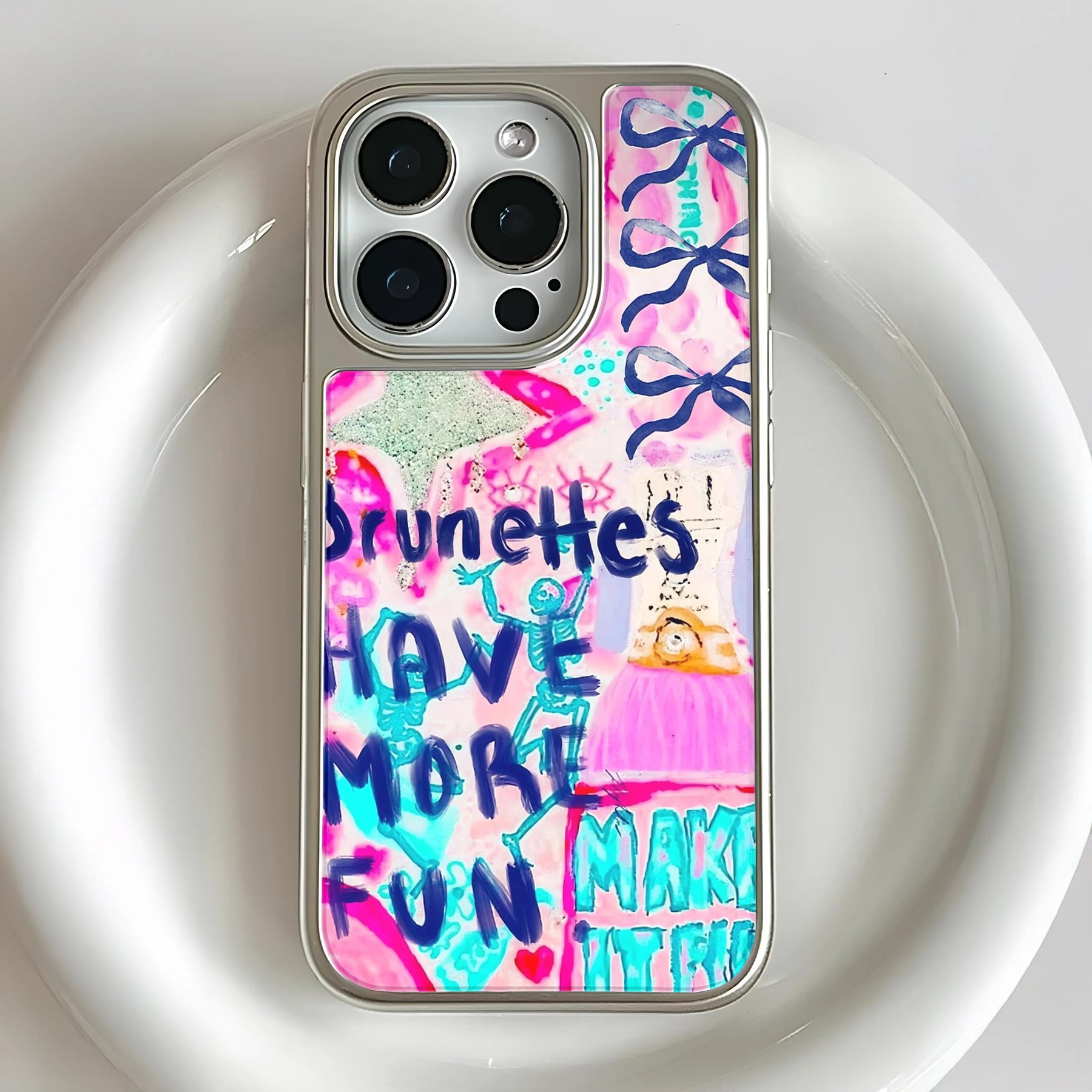 Silver phone case with pink blue doodle design, close-up rear camera angle