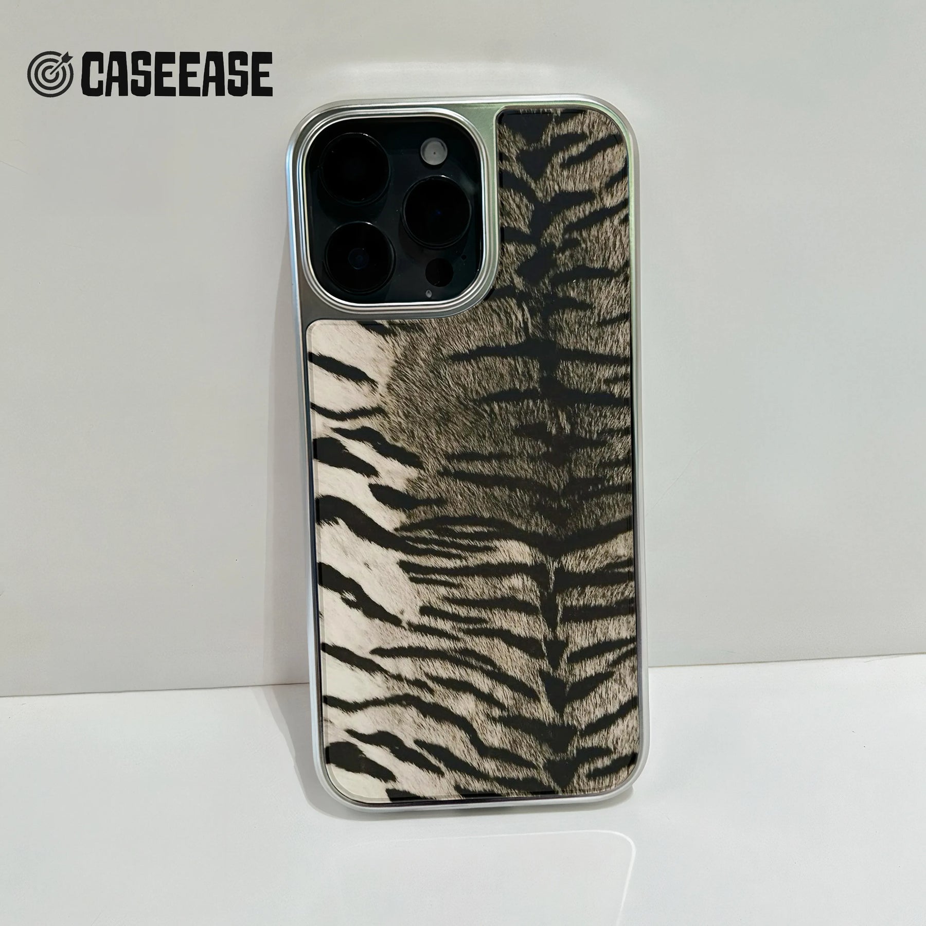 Silver phone case with black and beige zebra pattern, rear camera close-up