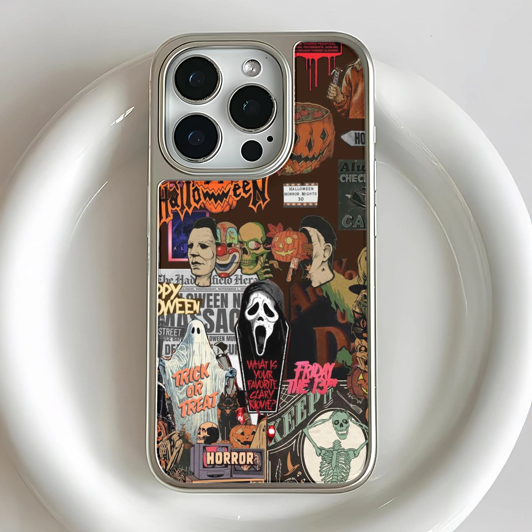 Silver iPhone case with colorful Halloween horror collage, close-up rear product angle