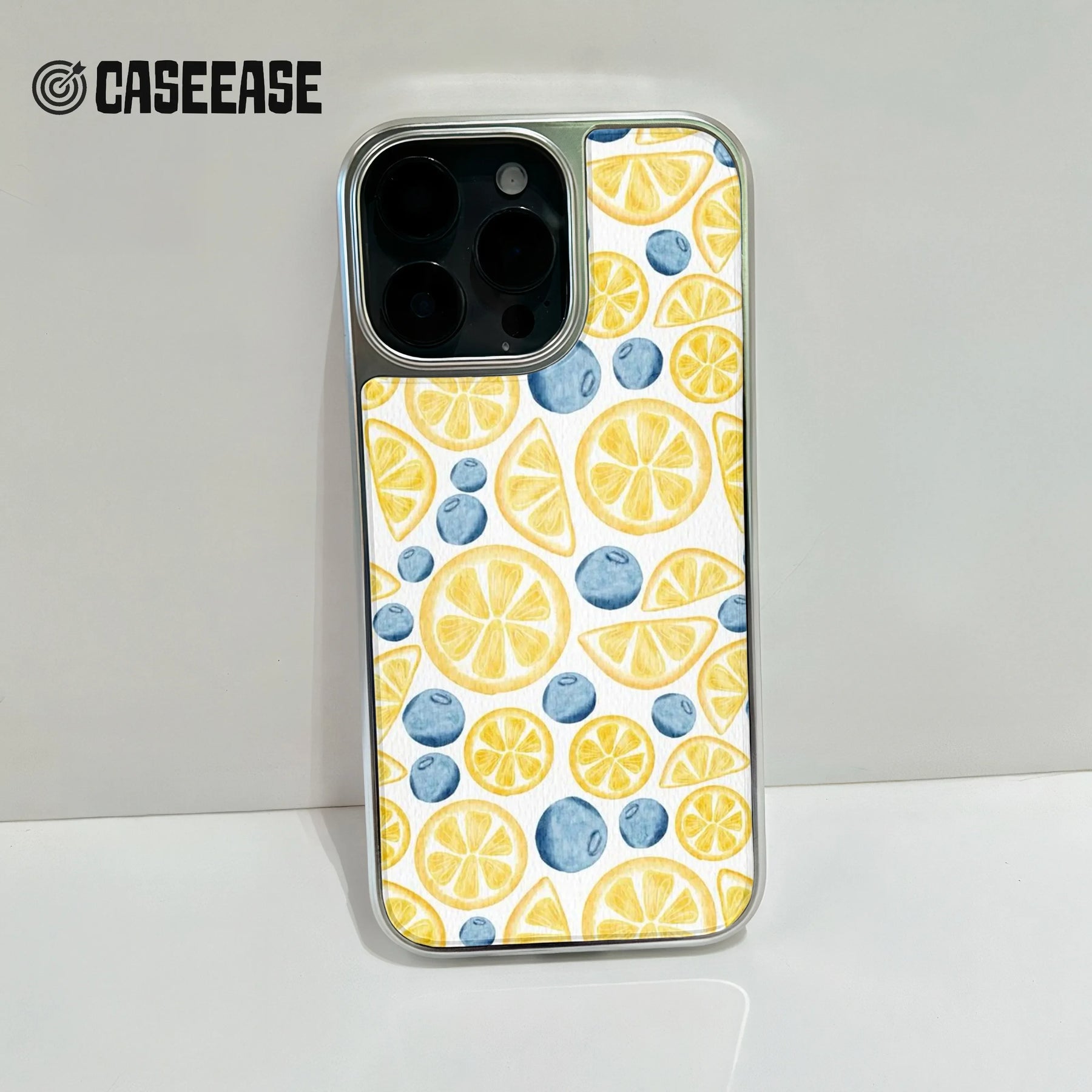 Silver phone case with lemon and blueberry pattern, rear close-up product angle