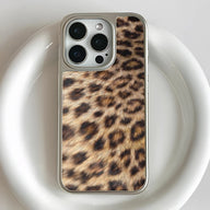 Silver smartphone case with leopard print, close-up rear camera angle on white surface