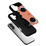 Black and peach plastic phone case with eye pattern, angled over silver smartphone