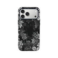 Black floral phone case shown from back with white flower pattern and camera cutout