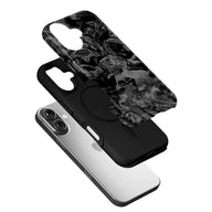 Black phone case with gray skull artwork shown angled above silver smartphone